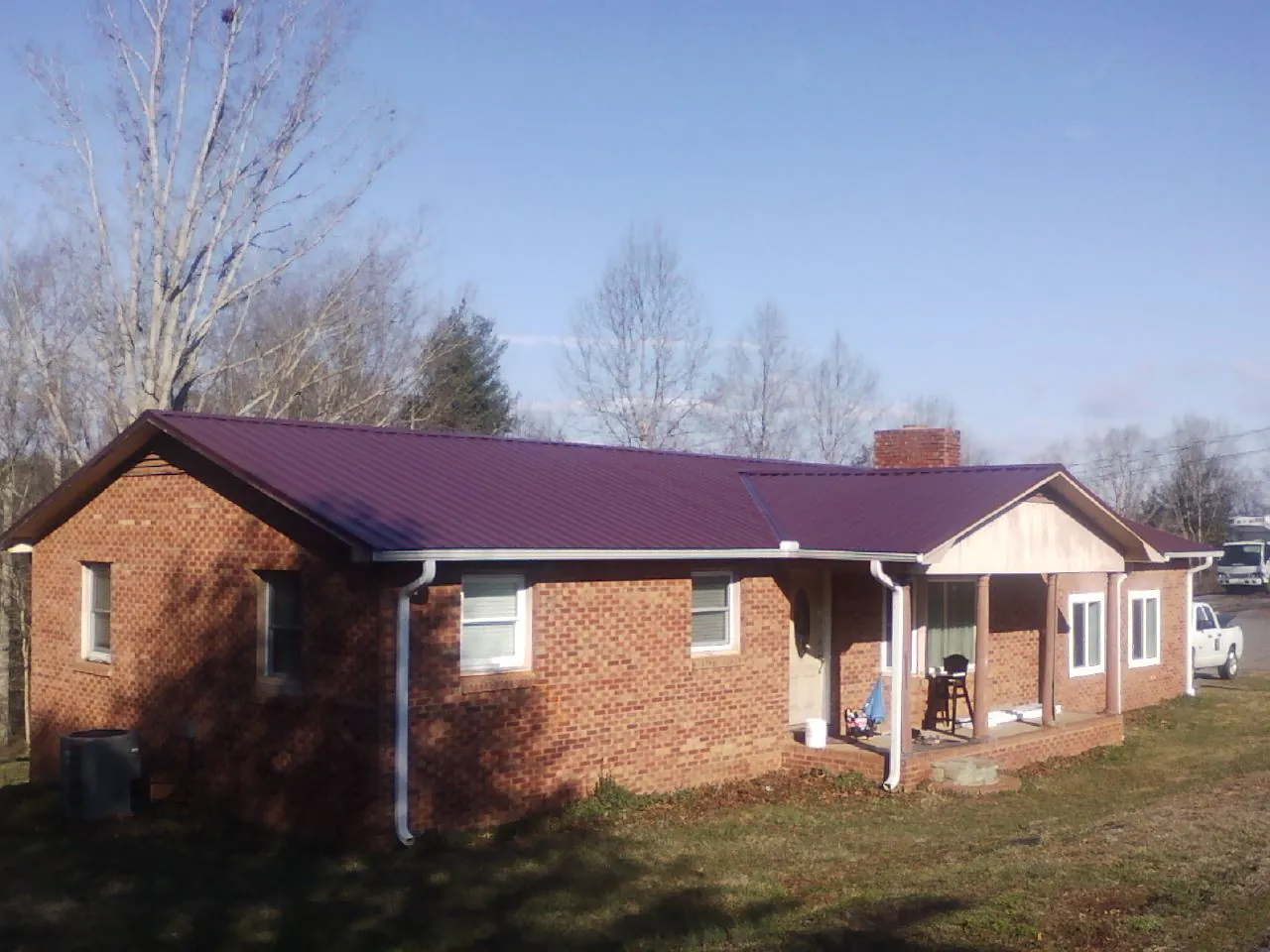 Burgundy metal roof on a brick ranch home with a new addition in Blairsburg