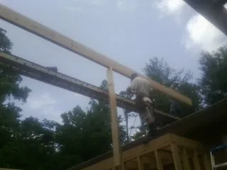 Carpenter setting a ridge beam over a new addition frame — Ice Dam Removal by Roofing Brothers in Blairsburg